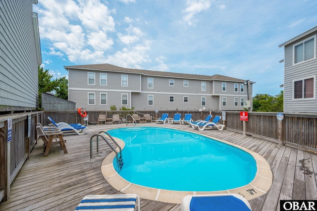 view of swimming pool with a fenced in pool, a residential view, and a deck