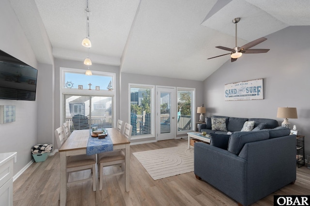 living area with a textured ceiling, wood finished floors, a ceiling fan, baseboards, and rail lighting