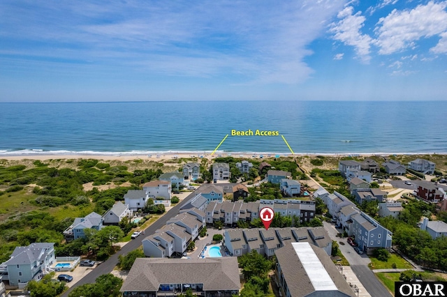 drone / aerial view with a view of the beach, a water view, and a residential view