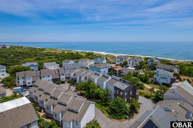 drone / aerial view featuring a water view, a view of the beach, and a residential view