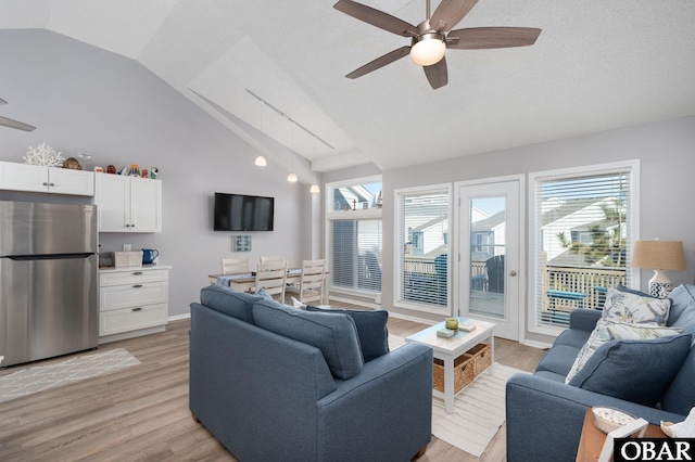 living area with light wood-style floors, plenty of natural light, and ceiling fan