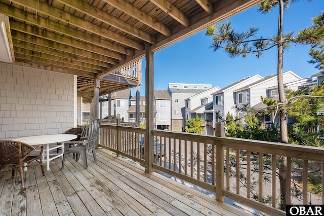 wooden deck with a residential view and outdoor dining area