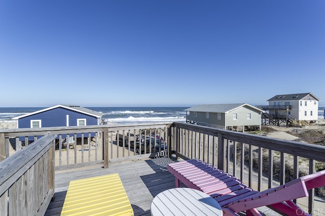 deck featuring a view of the beach and a water view