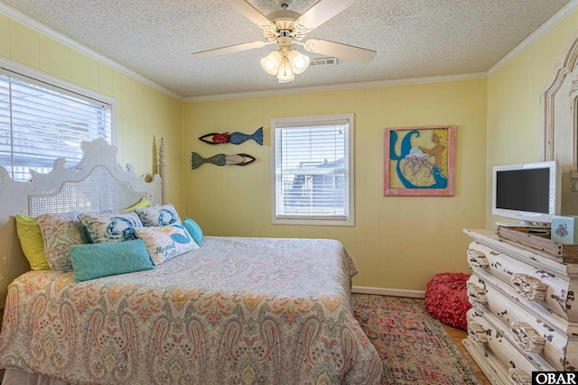 bedroom featuring a textured ceiling, ceiling fan, and ornamental molding