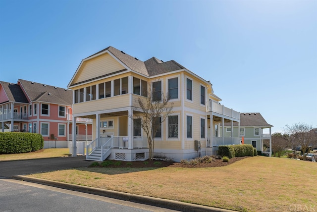 view of front of home featuring a residential view, a sunroom, and a front lawn