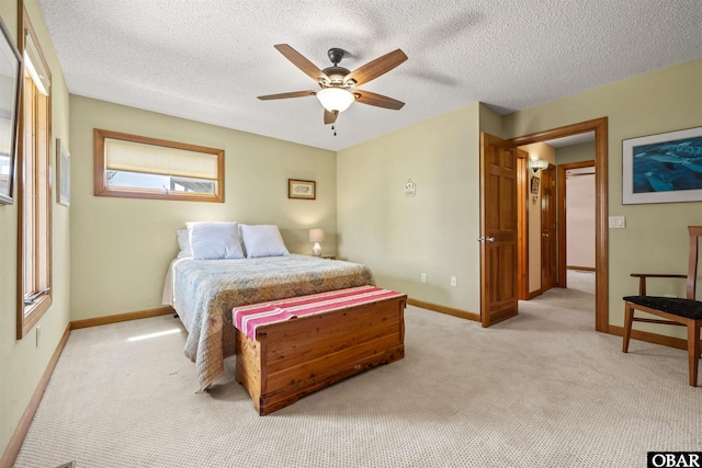 bedroom featuring a ceiling fan, baseboards, light carpet, and a textured ceiling