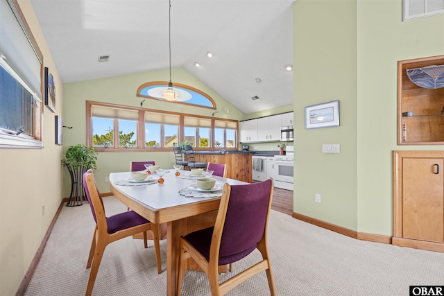 dining room featuring high vaulted ceiling, baseboards, light colored carpet, and visible vents