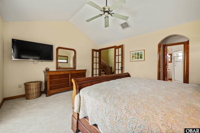 carpeted bedroom with ceiling fan, arched walkways, baseboards, lofted ceiling, and visible vents