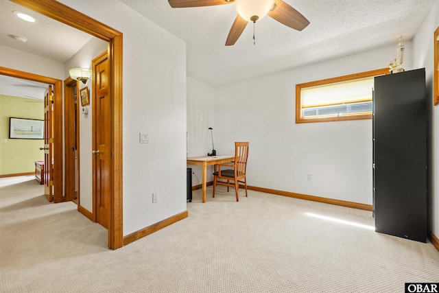 interior space with baseboards, a ceiling fan, and a textured ceiling