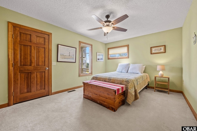 bedroom with visible vents, a textured ceiling, baseboards, and light carpet