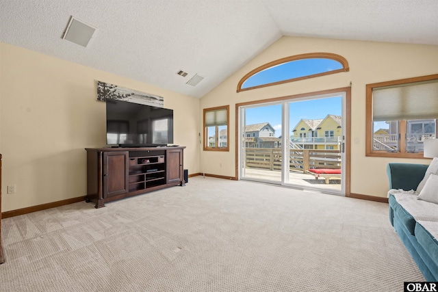 sitting room with baseboards, light carpet, vaulted ceiling, and visible vents