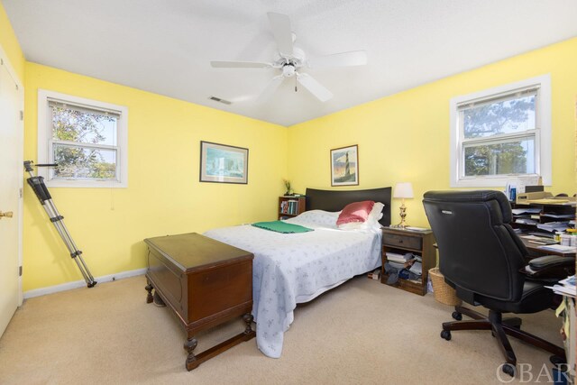 bedroom featuring light carpet, baseboards, multiple windows, and visible vents