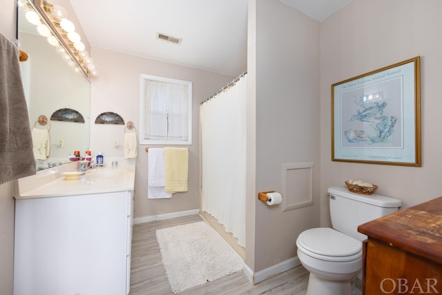 full bathroom featuring visible vents, vanity, toilet, and wood finished floors