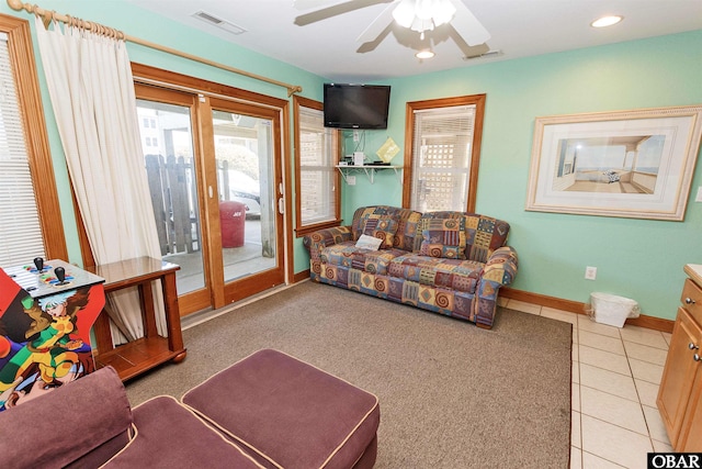 living room with baseboards, visible vents, ceiling fan, and tile patterned floors