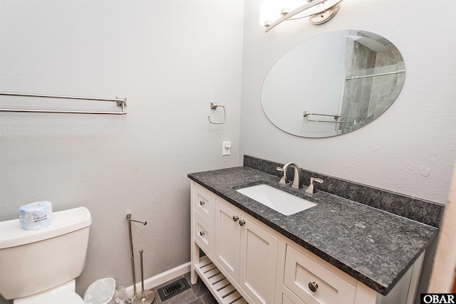 bathroom with toilet, visible vents, vanity, and baseboards