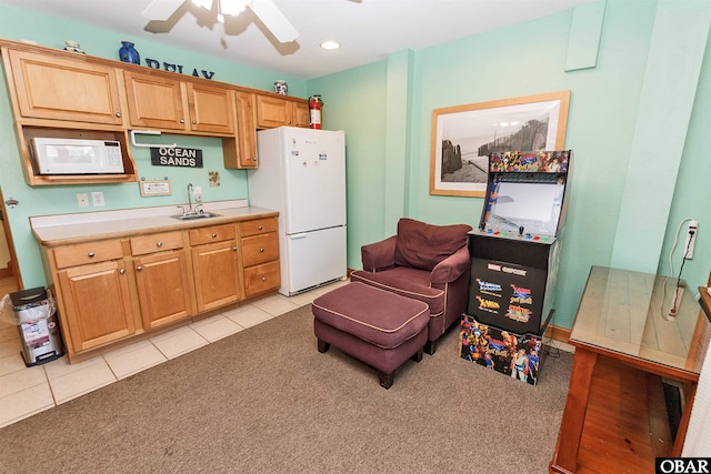 kitchen featuring light carpet, white appliances, light tile patterned floors, light countertops, and a sink