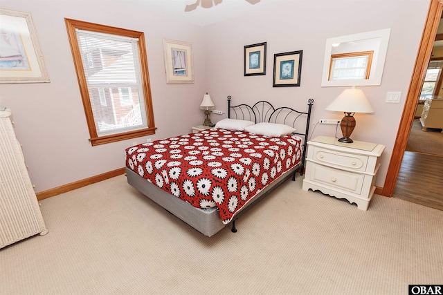 bedroom with light carpet, ceiling fan, and baseboards