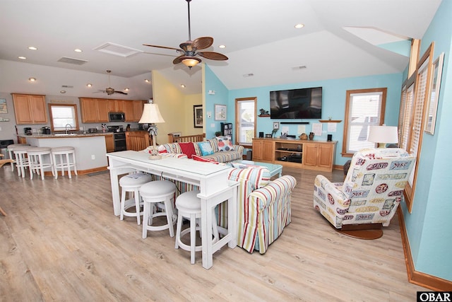 living area featuring light wood-type flooring, lofted ceiling, recessed lighting, and a ceiling fan