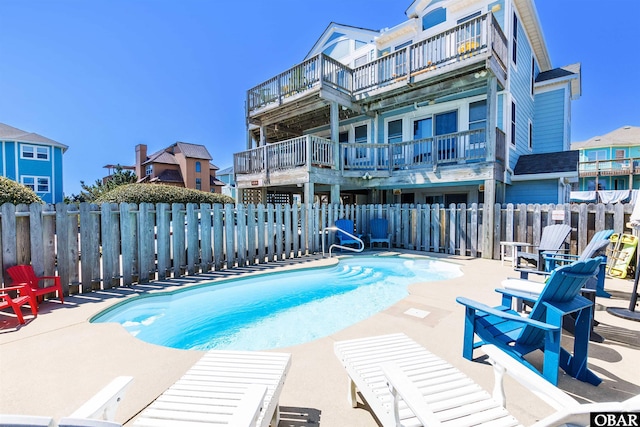 community pool with a patio area and fence