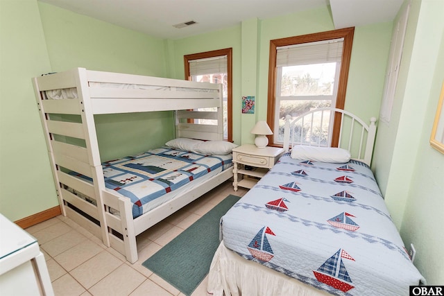 bedroom with light tile patterned floors, multiple windows, and visible vents