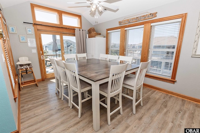 dining space with lofted ceiling, plenty of natural light, and light wood-style flooring