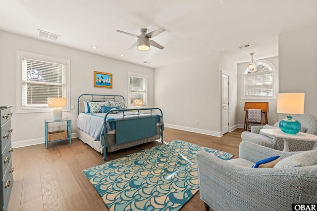 bedroom featuring multiple windows, wood finished floors, and visible vents