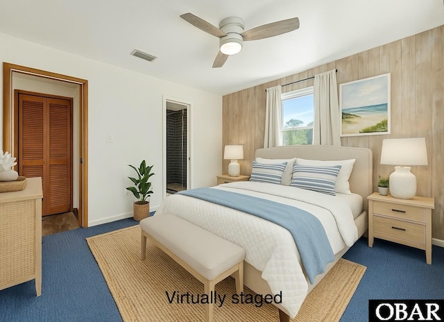 carpeted bedroom with baseboards, visible vents, a ceiling fan, and wooden walls