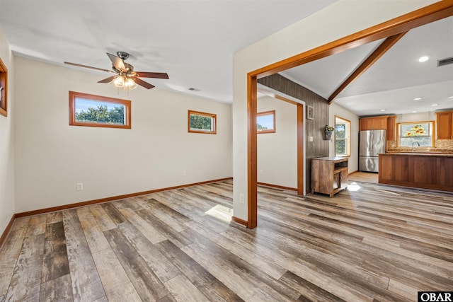 unfurnished living room featuring baseboards, visible vents, wood finished floors, and a ceiling fan