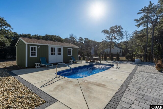view of pool featuring a fenced in pool, a patio area, an outbuilding, fence, and an exterior structure