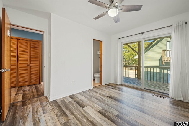 interior space featuring hardwood / wood-style floors, visible vents, access to exterior, and baseboards
