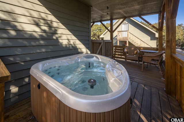 wooden deck featuring stairway and a hot tub