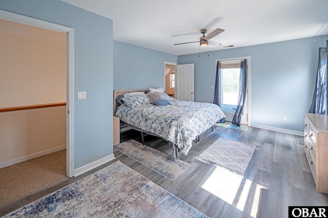 bedroom featuring visible vents, wood finished floors, a ceiling fan, and baseboards