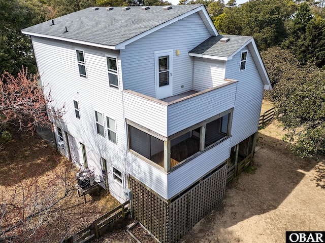 rear view of house with roof with shingles