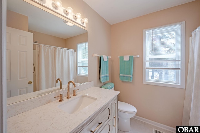 full bathroom with a healthy amount of sunlight, toilet, vanity, and baseboards