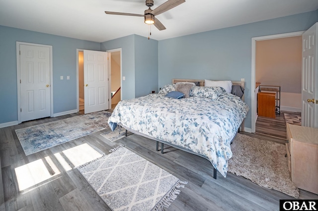 bedroom featuring a ceiling fan, baseboards, and wood finished floors