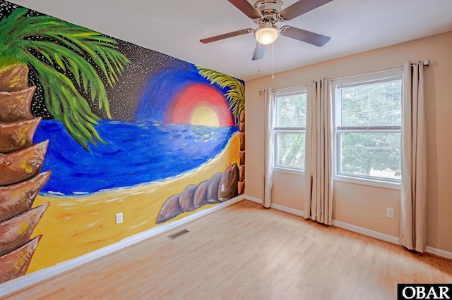 unfurnished bedroom featuring a ceiling fan, baseboards, visible vents, and wood finished floors