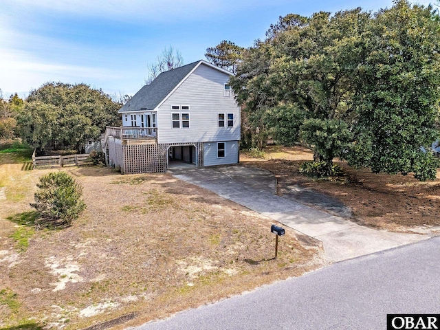 view of front of property featuring stairs, a carport, and driveway