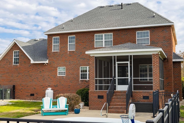 back of property with a sunroom, brick siding, and roof with shingles