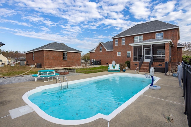view of pool with a sunroom, a patio, a fenced in pool, cooling unit, and fence