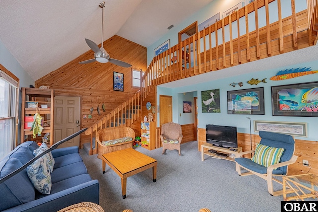 26224 Cutlass Ln Lot 27, Salvo, NC 27972 - carpeted living area with wooden walls, high vaulted ceiling, a ceiling fan, and stairs