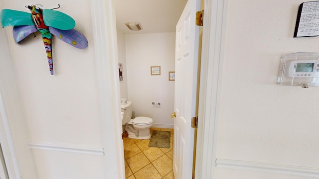 bathroom featuring toilet, tile patterned flooring, and baseboards