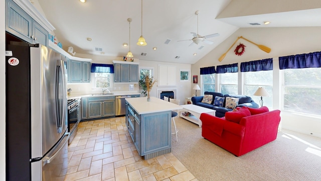 kitchen with a center island, pendant lighting, light countertops, appliances with stainless steel finishes, and open floor plan