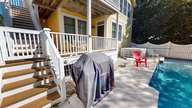 view of patio / terrace featuring stairs, area for grilling, fence, and a hot tub