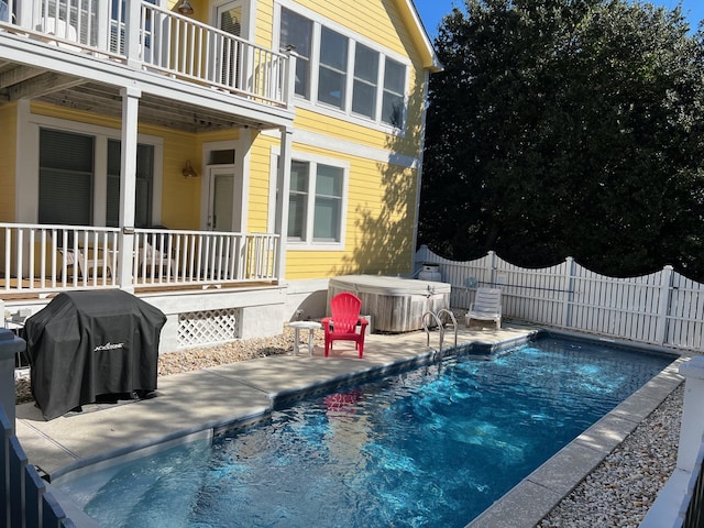 view of pool featuring a patio area, a hot tub, fence, and a grill