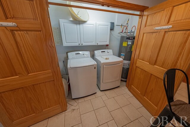 washroom with water heater, washing machine and dryer, and cabinet space