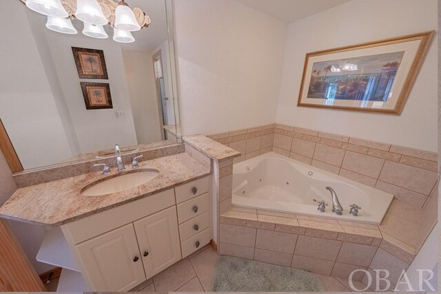 full bathroom with a whirlpool tub, an inviting chandelier, tile patterned flooring, and vanity