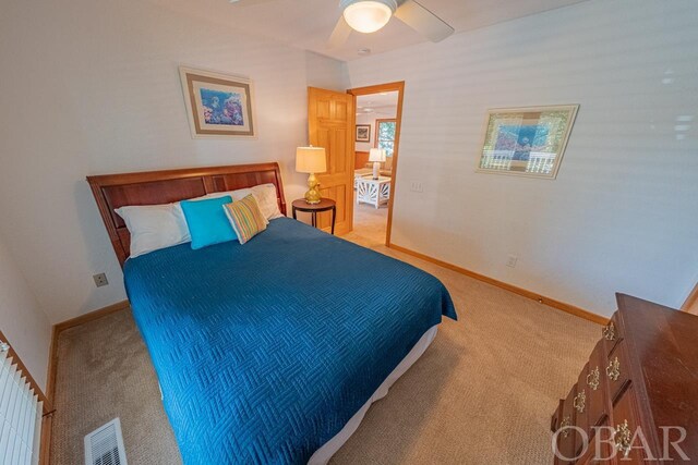 bedroom featuring light carpet, a ceiling fan, visible vents, and baseboards