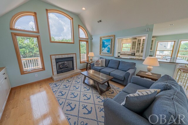 living room with plenty of natural light, light wood finished floors, a fireplace, and visible vents