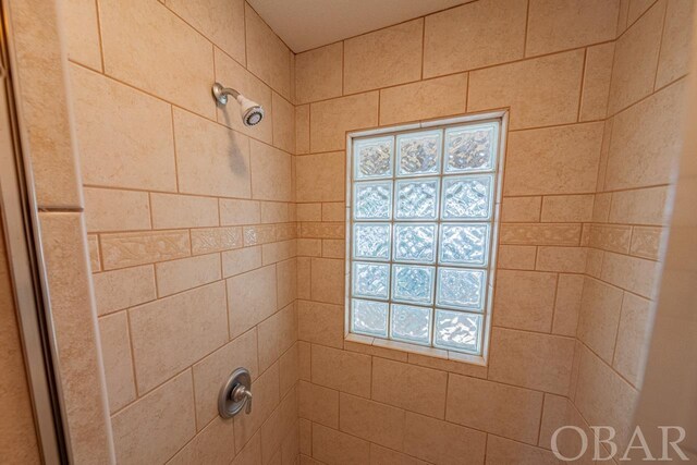 interior details featuring a tile shower