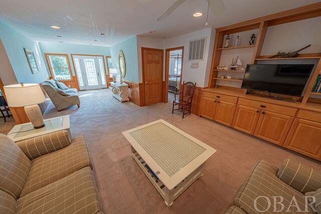 living area with light carpet, visible vents, a ceiling fan, and recessed lighting